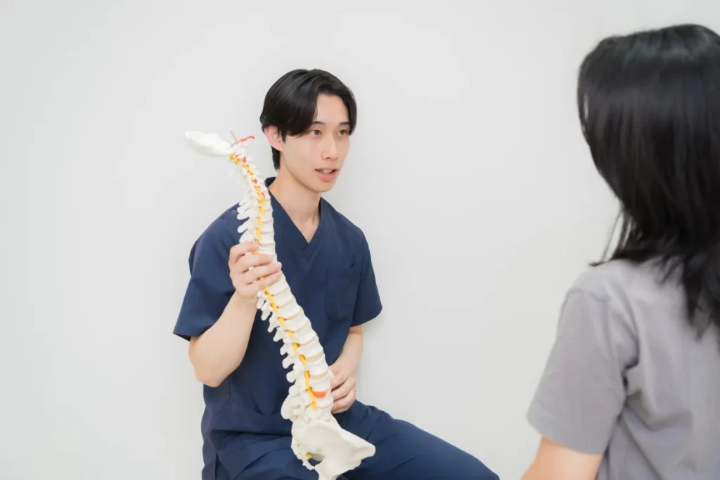 施術者が背骨の模型を示しながら説明する様子
